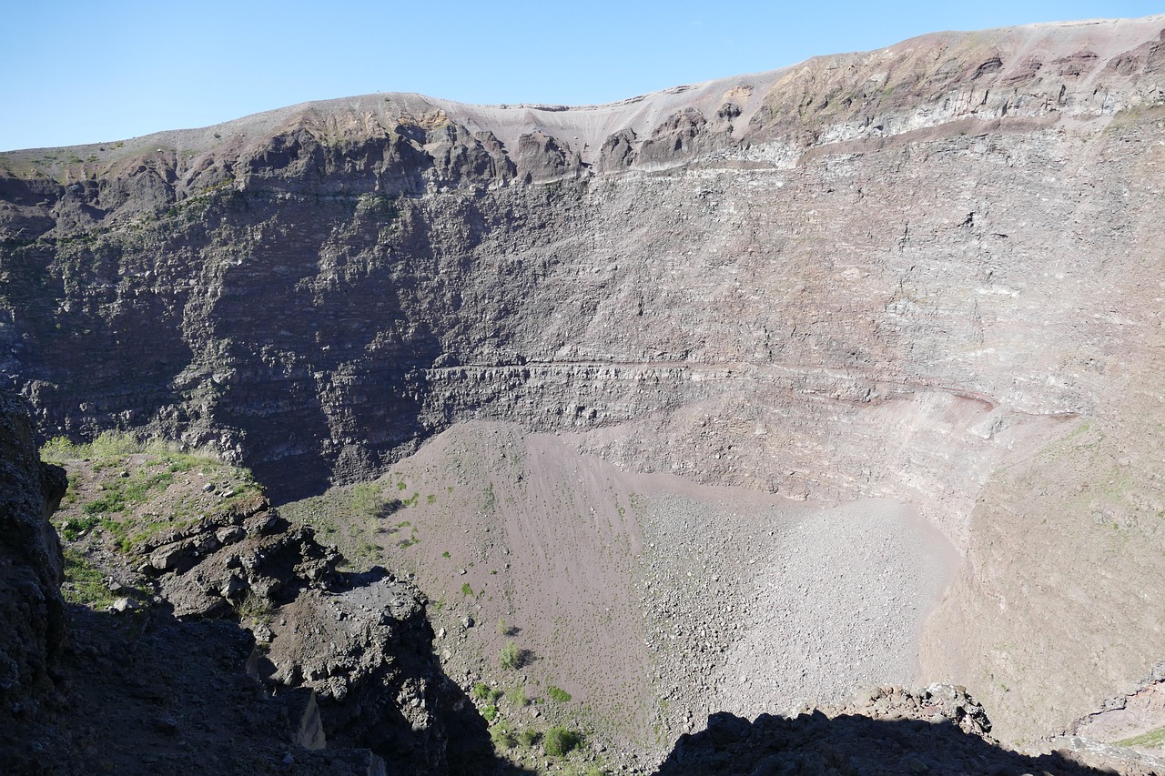 Inside the crater of Mount Vesuvius, with steep rocky walls and a slope of gravel at the bottom.